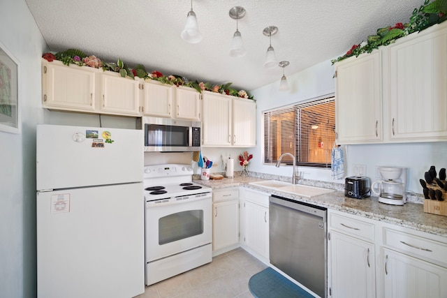 kitchen with light tile patterned floors, pendant lighting, appliances with stainless steel finishes, and a sink