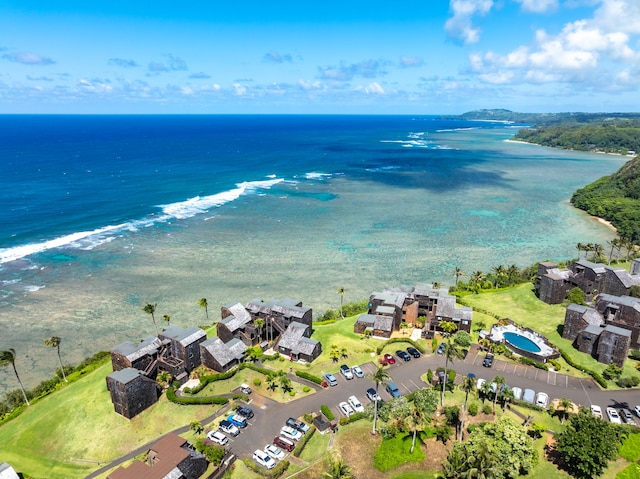 birds eye view of property with a water view and a beach view