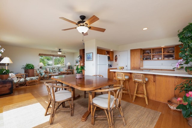 dining room with light wood-style flooring, ceiling fan, and recessed lighting
