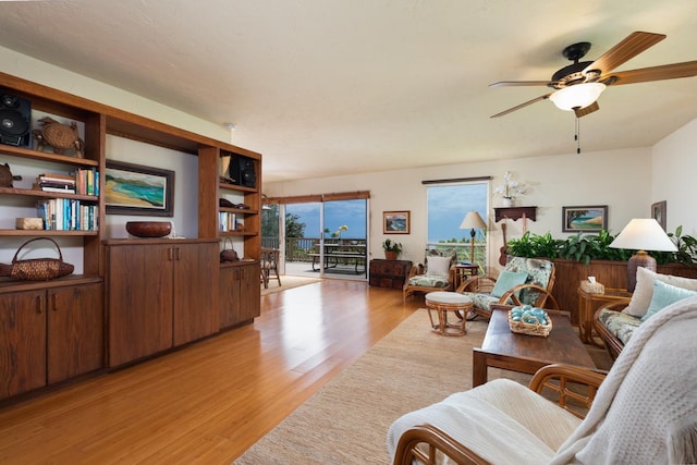 living area with light wood-style flooring and a ceiling fan