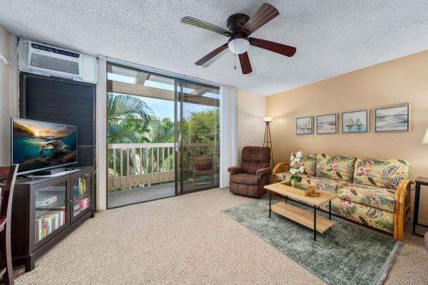 carpeted living area featuring a textured ceiling, a ceiling fan, a wall of windows, and a wall unit AC
