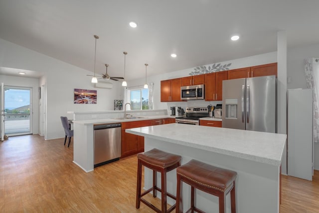 kitchen with light countertops, a peninsula, appliances with stainless steel finishes, and a sink