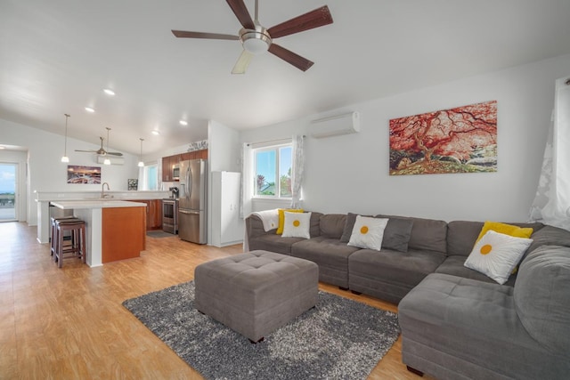 living area with light wood finished floors, vaulted ceiling, ceiling fan, and an AC wall unit