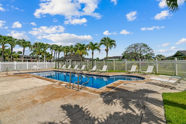 community pool with a patio area and fence