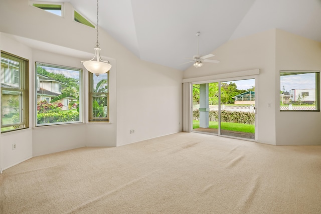 carpeted spare room with ceiling fan and high vaulted ceiling