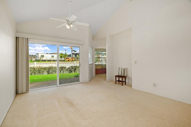 empty room with carpet flooring, high vaulted ceiling, and a ceiling fan