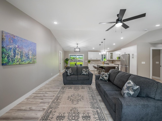 living room featuring lofted ceiling, light wood-type flooring, ceiling fan, recessed lighting, and baseboards