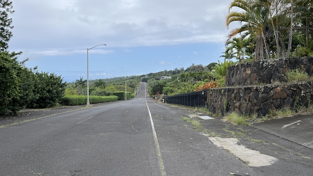 view of asphalt road with street lights