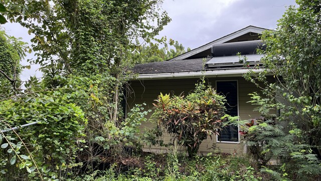 view of side of home with a shingled roof