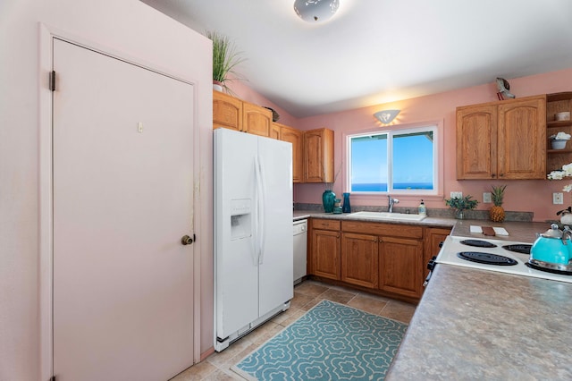 kitchen with white appliances, a sink, light tile patterned floors, brown cabinetry, and open shelves
