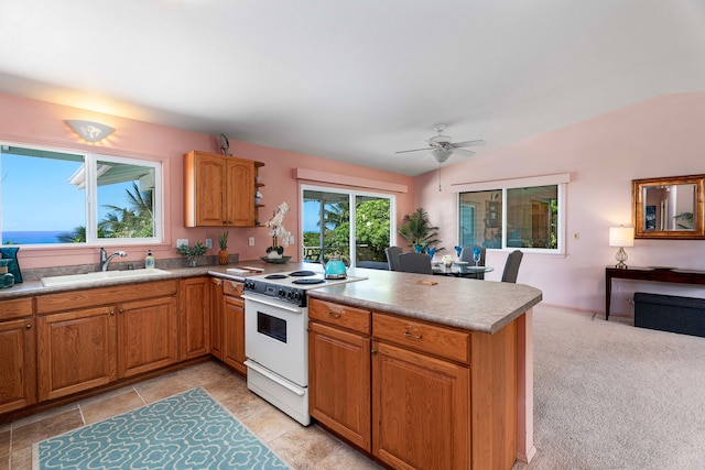 kitchen featuring white range with electric stovetop, a sink, a peninsula, vaulted ceiling, and ceiling fan