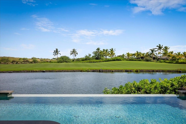 view of swimming pool featuring a water view, golf course view, and a lawn