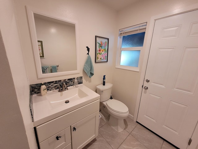 half bathroom featuring vanity, toilet, and tile patterned floors