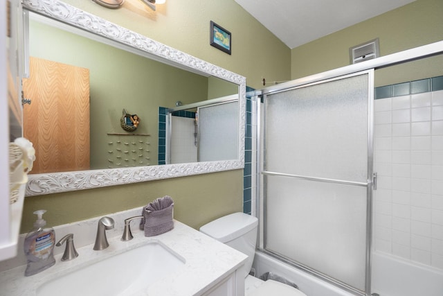 bathroom featuring toilet, enclosed tub / shower combo, and vanity