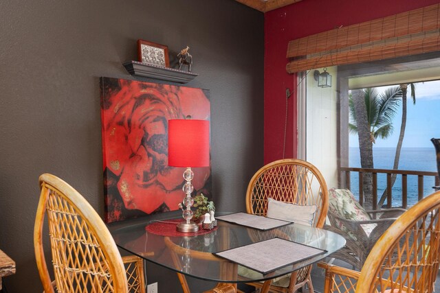 dining room with a water view and a textured wall