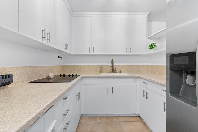 kitchen featuring stainless steel fridge with ice dispenser, black electric cooktop, a sink, open shelves, and light countertops
