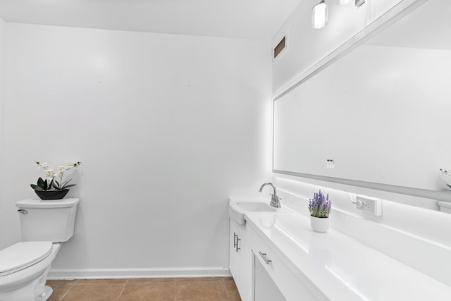 half bathroom featuring vanity, baseboards, toilet, and tile patterned floors