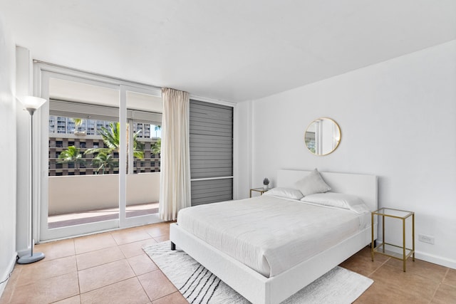 bedroom with light tile patterned floors, access to exterior, and baseboards