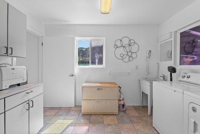 clothes washing area with washing machine and clothes dryer and cabinet space