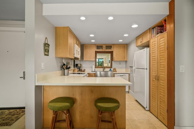 5380 Honoiki Rd Unit F16, Princeville, HI 96722 - kitchen with white appliances, a sink, a peninsula, light countertops, and a kitchen bar