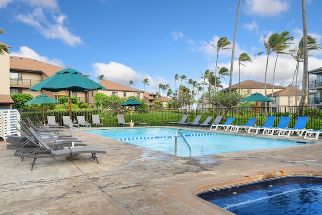 community pool with fence, a patio, and a residential view