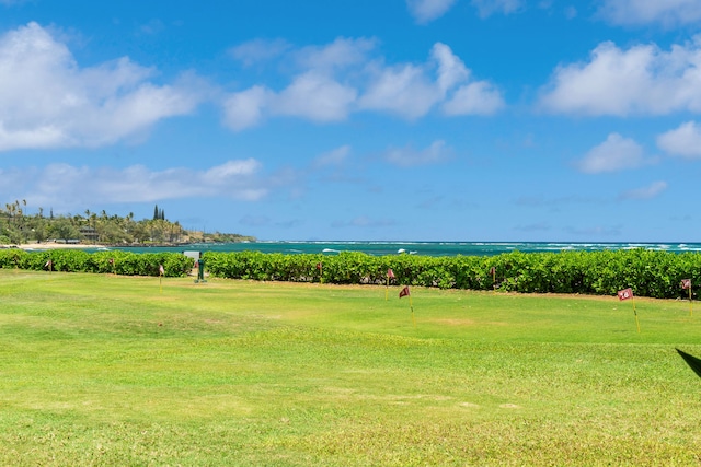 view of community with an area to practice putting, a water view, golf course view, and a yard