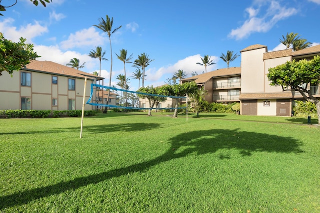 view of property's community with volleyball court and a lawn