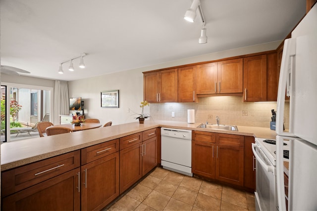 kitchen with white appliances, rail lighting, and brown cabinetry