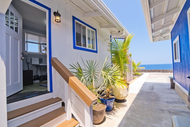 view of exterior entry featuring view of water and beach