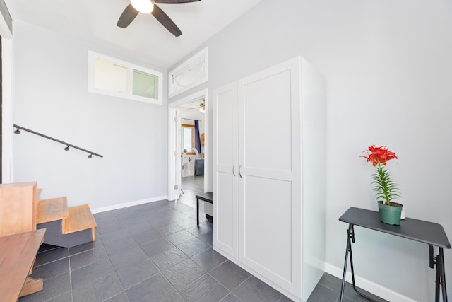 staircase featuring ceiling fan and baseboards
