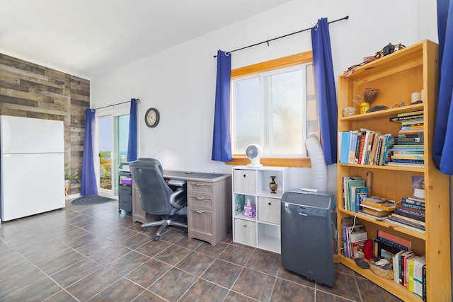 home office featuring dark tile patterned floors and wood walls