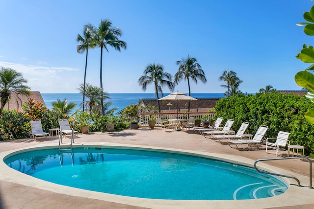 community pool with a patio and a water view