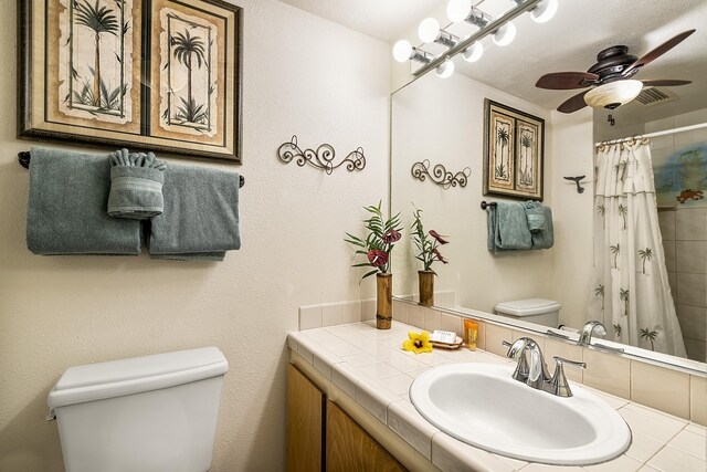 full bathroom featuring toilet, ceiling fan, vanity, and a shower with curtain