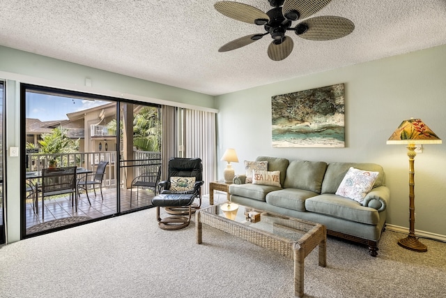 living room with carpet flooring, a ceiling fan, and a textured ceiling
