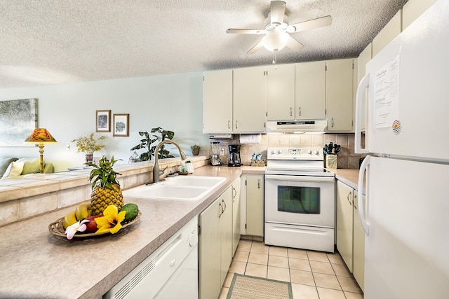 kitchen featuring white appliances, a sink, under cabinet range hood, a textured ceiling, and ceiling fan