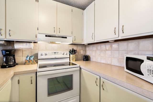 kitchen featuring white appliances, under cabinet range hood, light countertops, and decorative backsplash