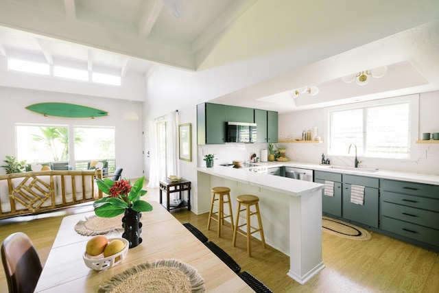 3880 Wyllie Rd Unit 5A, Princeville, HI 96722 - kitchen with green cabinets, a sink, a peninsula, open shelves, and plenty of natural light