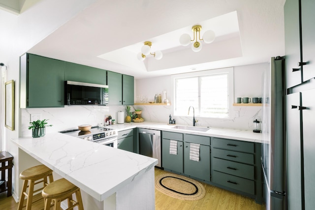 3880 Wyllie Rd Unit 5A, Princeville, HI 96722 - kitchen with appliances with stainless steel finishes, a sink, green cabinets, a peninsula, and a raised ceiling