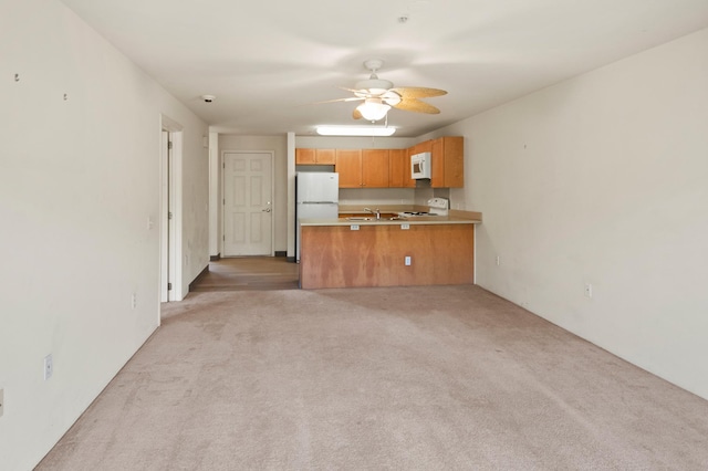 3920 Haoa St Unit 322, Lihue, HI 96766 - kitchen featuring white appliances, light carpet, a ceiling fan, a peninsula, and light countertops