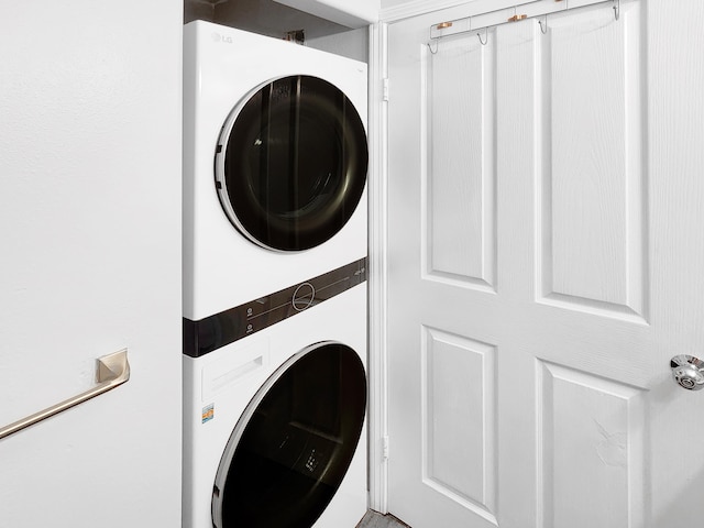 clothes washing area featuring stacked washer / dryer