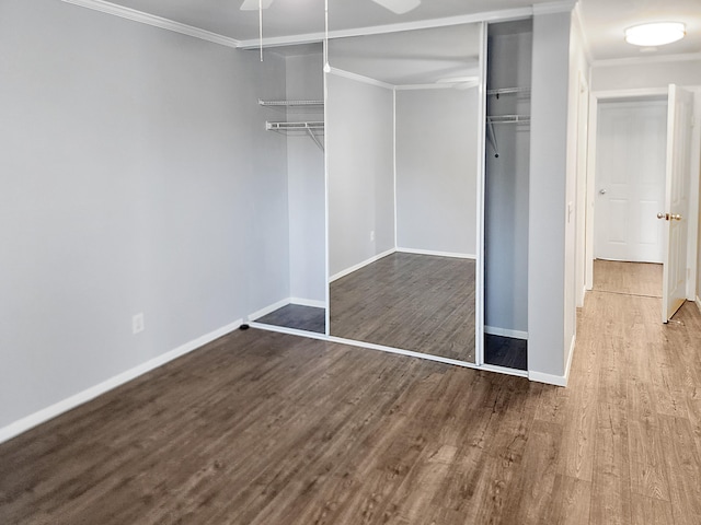 unfurnished bedroom with wood finished floors, baseboards, and ornamental molding