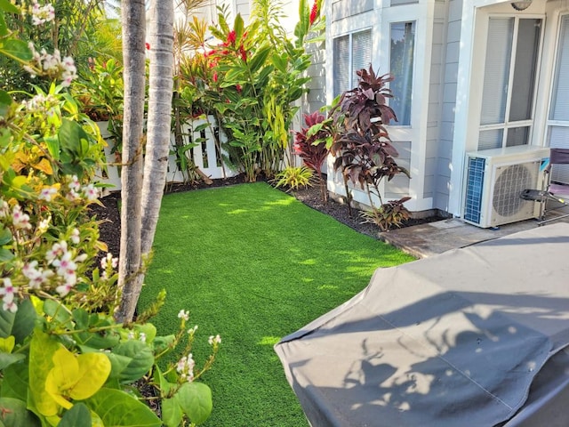 view of green lawn featuring ac unit