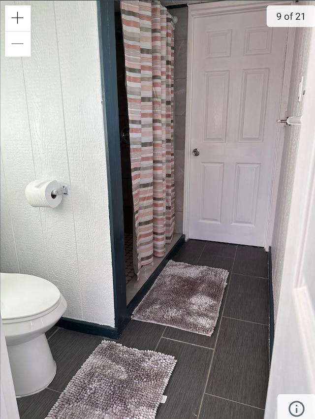 full bath featuring tile patterned flooring, curtained shower, and toilet