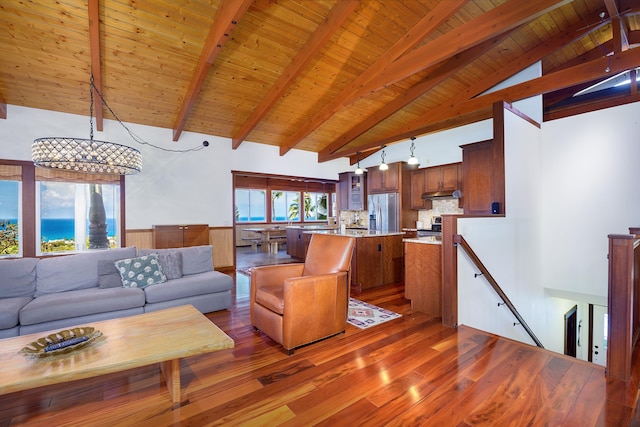 living room featuring hardwood / wood-style floors, beam ceiling, high vaulted ceiling, wooden ceiling, and a chandelier