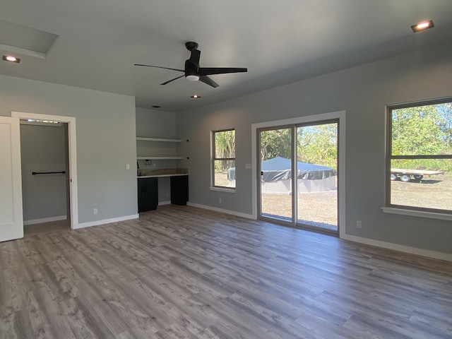 unfurnished living room featuring wood finished floors, a ceiling fan, and baseboards