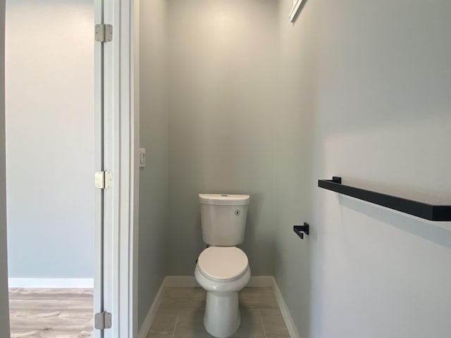 bathroom with toilet and baseboards