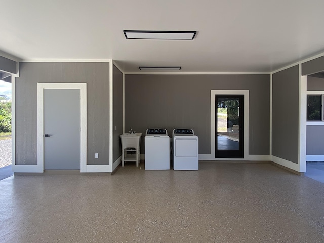 spare room featuring washing machine and clothes dryer, plenty of natural light, a sink, and baseboards