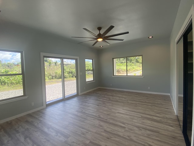 spare room with healthy amount of natural light, wood finished floors, ceiling fan, and recessed lighting