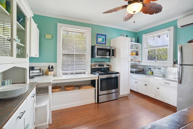 4-950 Kuhio Hwy, Kapaa, HI 96746 - kitchen featuring appliances with stainless steel finishes, an AC wall unit, dark wood finished floors, crown molding, and a ceiling fan