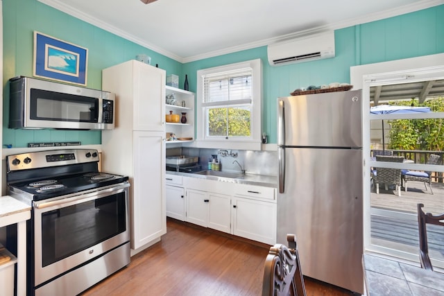 4-950 Kuhio Hwy, Kapaa, HI 96746 - kitchen featuring appliances with stainless steel finishes, white cabinetry, a wall unit AC, ornamental molding, and a sink